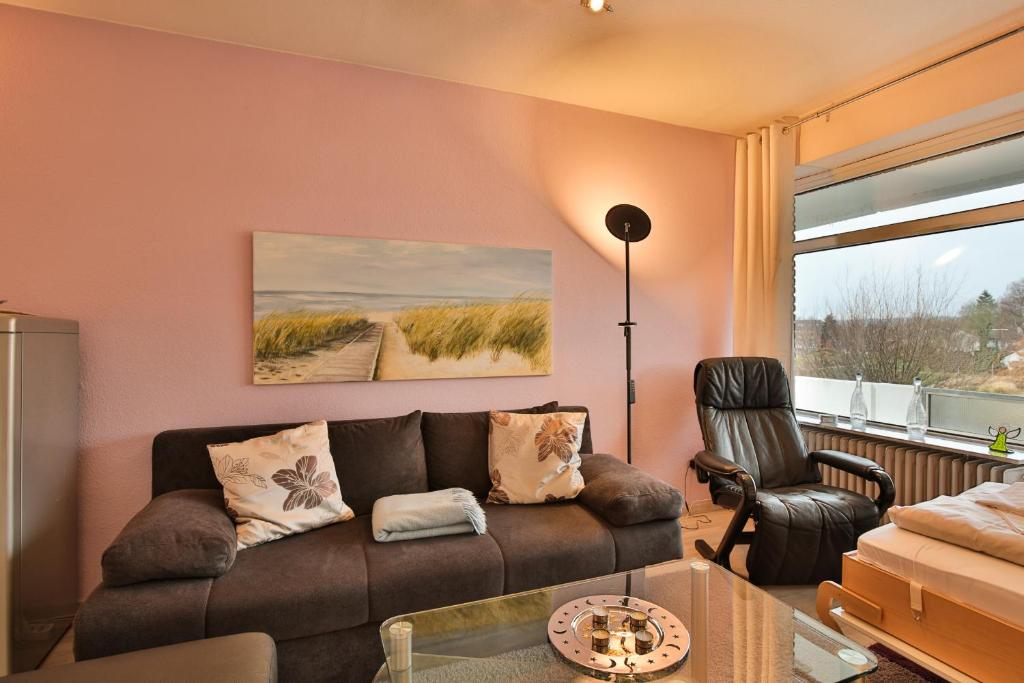 uma sala de estar com um sofá e uma cadeira em Strandperle Strandperle Appartement 201 em Haffkrug