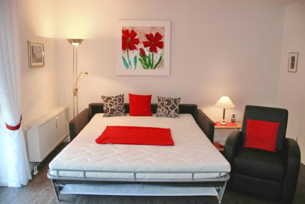 - une chambre avec un grand lit blanc et une chaise dans l'établissement Residenz am Fischerstieg Residenz am Fischerstieg Appartement 17, à Scharbeutz