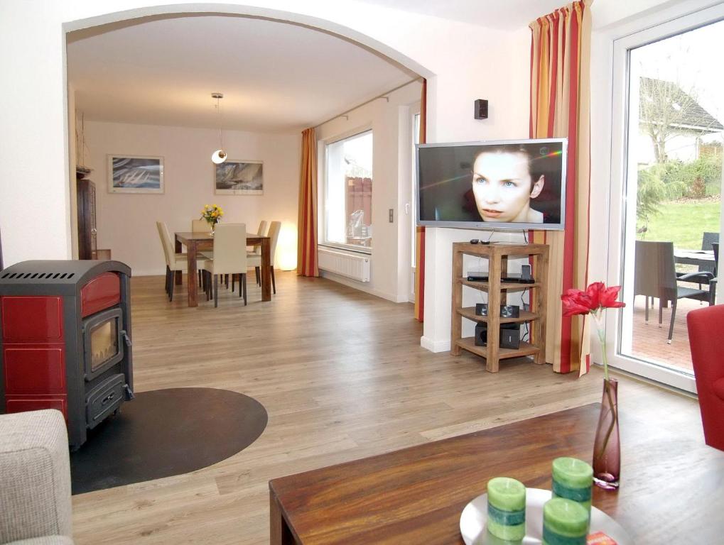 ein Wohnzimmer mit einem Flachbild-TV und einem Tisch in der Unterkunft Ferienhaus LUV & LEE Ferienhaus LUV und LEE in Scharbeutz