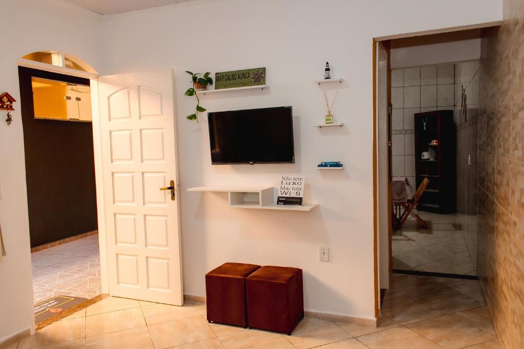 a living room with a tv on a wall at Moni & Junior Hospedagem in Angra dos Reis