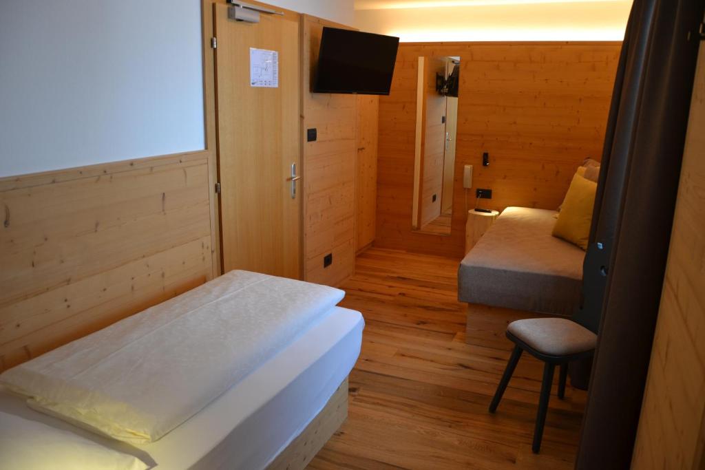 a cozy room with alpine charm. A single bed in a room at Hotel Ortler 