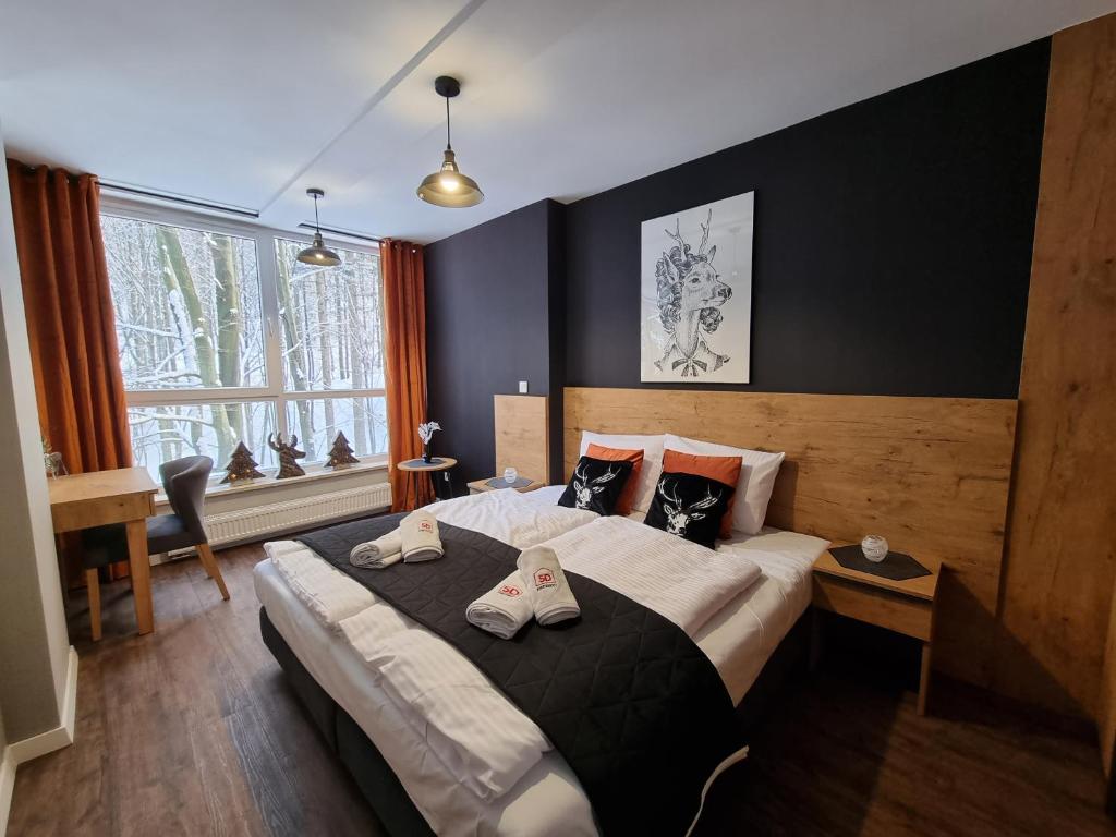 什切爾克的住宿－Apartament 10 Resort Kozubnik Kiczora - 5D Apartamenty，一间卧室配有一张大床和两条毛巾