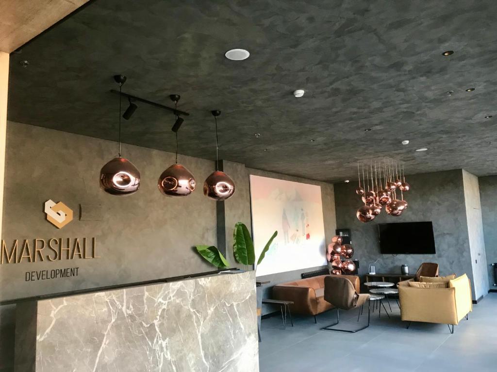 a lobby with pendant lights and a table and chairs at Marshal Gudauri in Gudauri