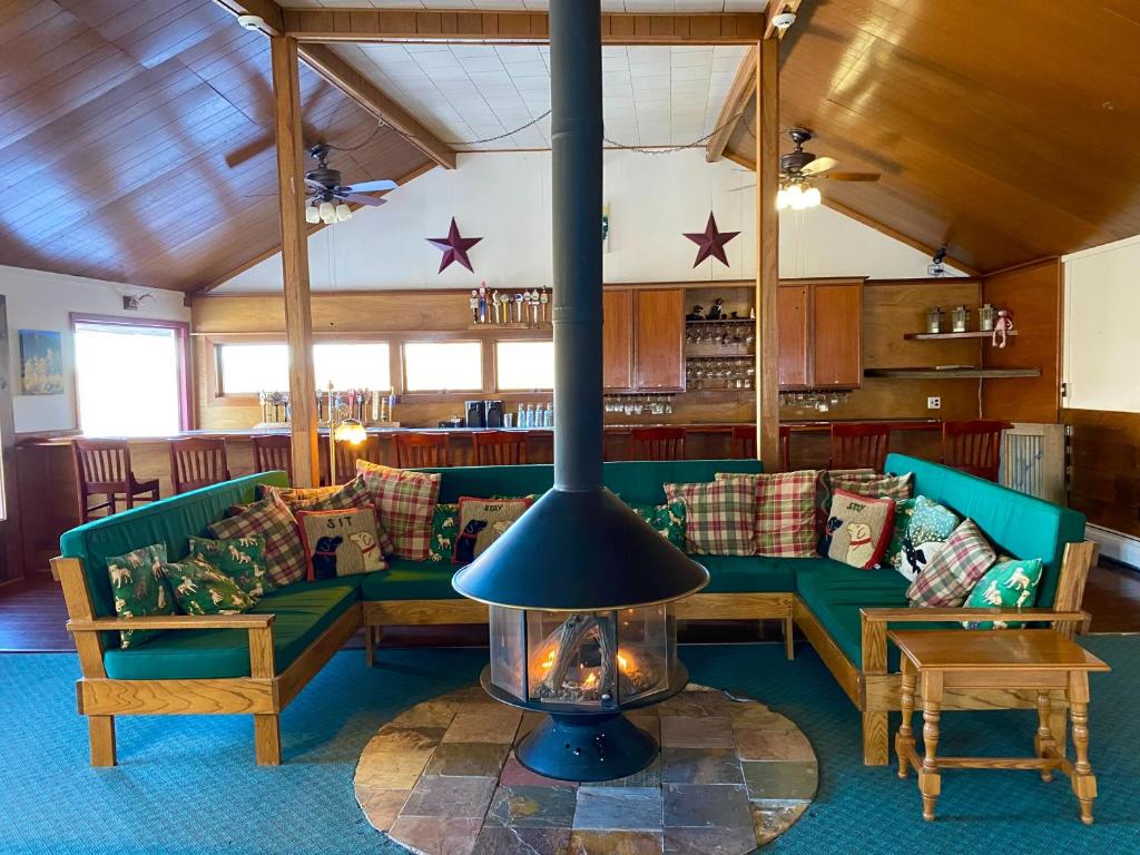 a living room with green couches and a fireplace at Bromley View Inn in Bondville