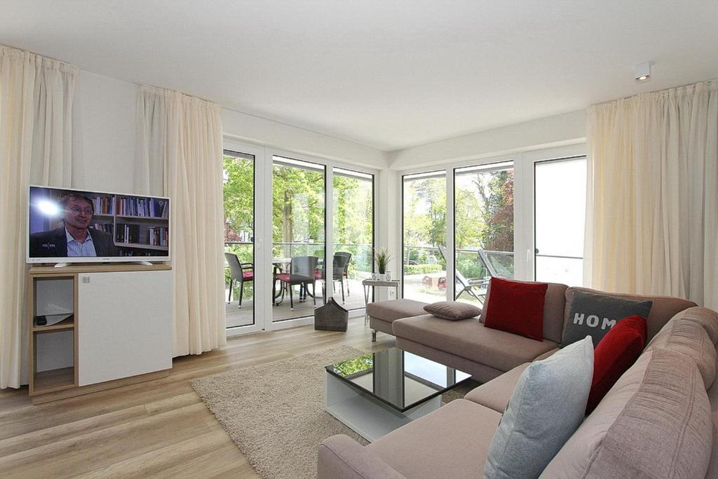 ein Wohnzimmer mit einem Sofa und einem Flachbild-TV in der Unterkunft Villa Stern Villa Stern Appartement 06 in Timmendorfer Strand