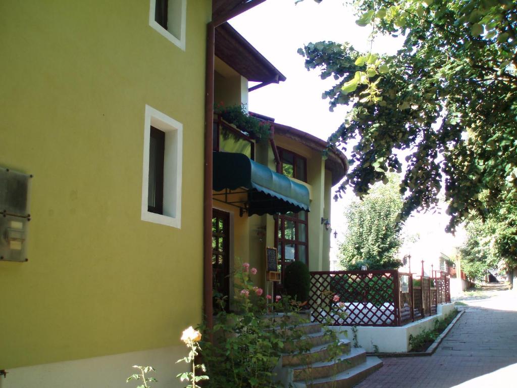 a yellow building with a gate and stairs next to it at Pension Edelweiss in Eforie Sud