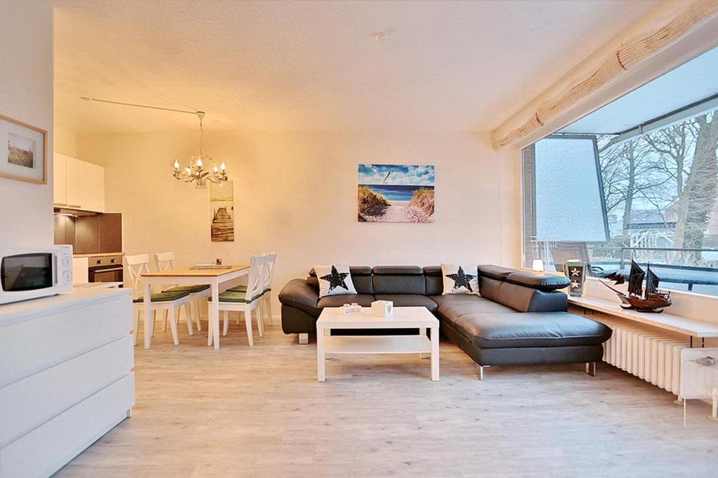 ein Wohnzimmer mit einem Sofa und einem Tisch in der Unterkunft Haus am Höppnerweg 5 Haus am Höppnerweg 5 Appartement 09 in Timmendorfer Strand