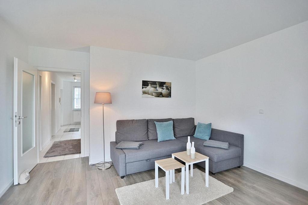 een woonkamer met een bank en een tafel bij Haus Ostseeallee Ostseeallee Appartement 56 in Niendorf