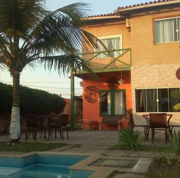 a house with a palm tree and a table and chairs at VIDA DE BUZIOS in Búzios