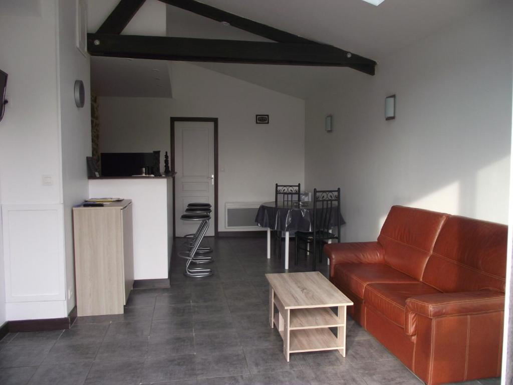 ein Wohnzimmer mit einem Sofa und einem Tisch in der Unterkunft La campagne au pied du MT ST MICHEL in Roz-sur-Couesnon
