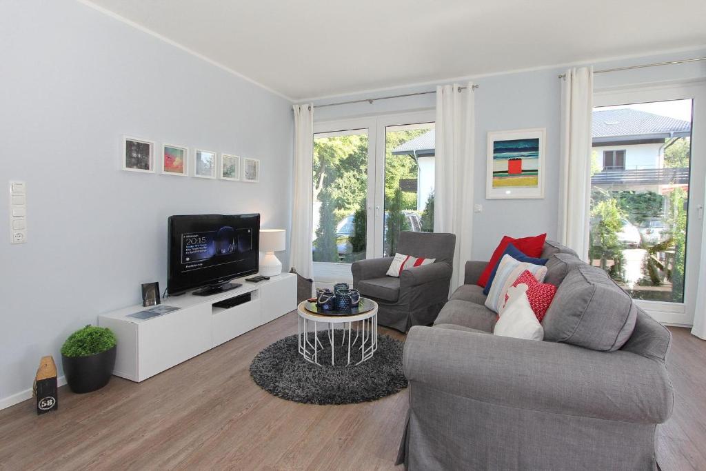uma sala de estar com dois sofás e uma televisão em Haus am Hörn Tide am Hörn em Scharbeutz