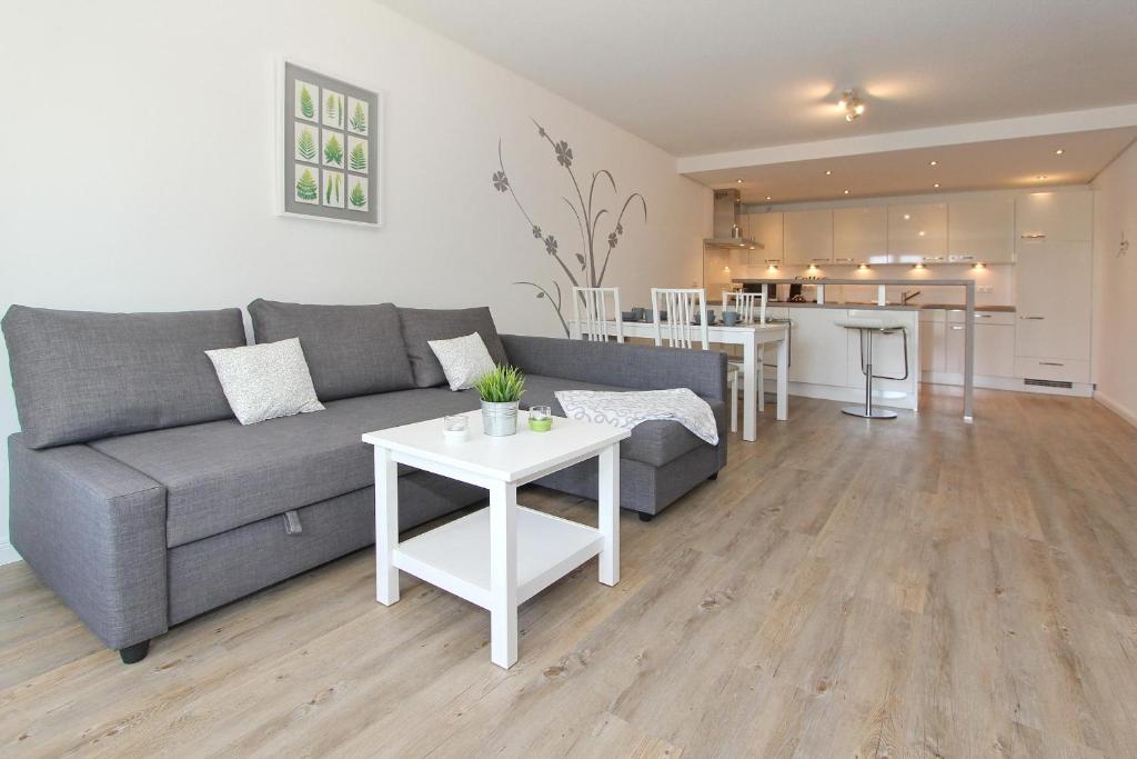 a living room with a couch and a table at Kurparkresidenz Kurparkresidenz Appartement 11 in Scharbeutz