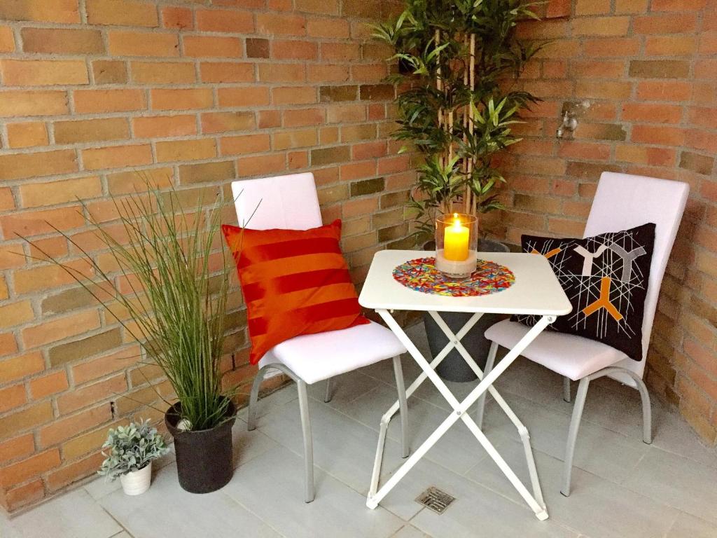 2 Stühle und ein Tisch mit Kerzen auf der Terrasse in der Unterkunft Residenz Ostseestrand Appartement 32 in Scharbeutz