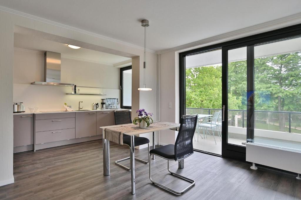 a kitchen with a table and chairs in a room at Haus Stranddistel Stranddistel Appartement 2 in Scharbeutz