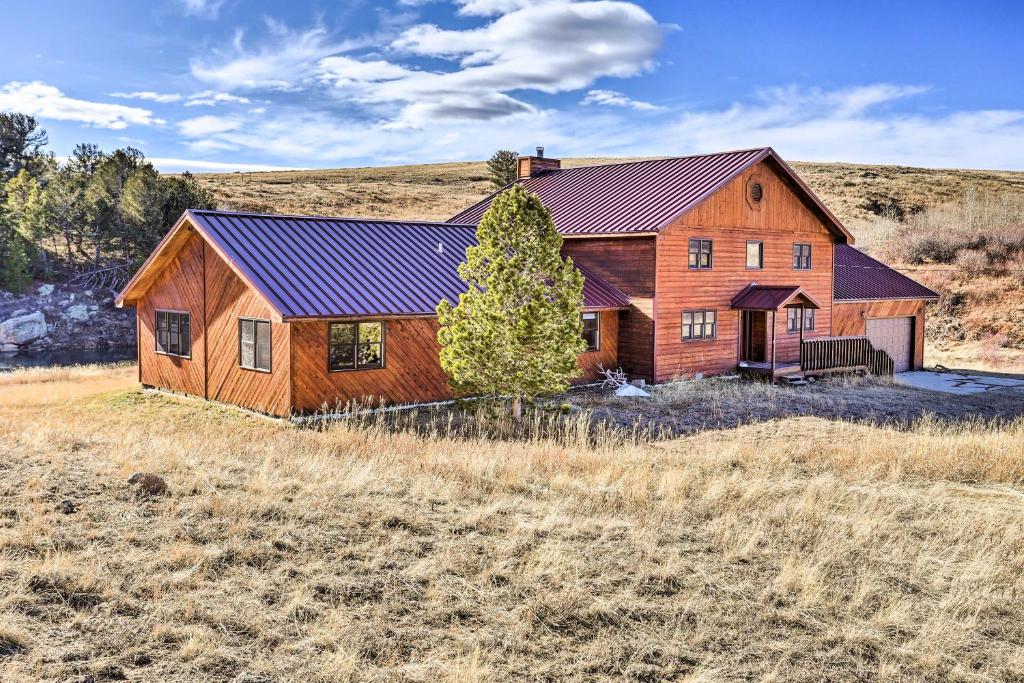 una casa in legno con tetto rosso in un campo di Remote WY Ranch with 170 Acres and Views Galore! a Glenrock