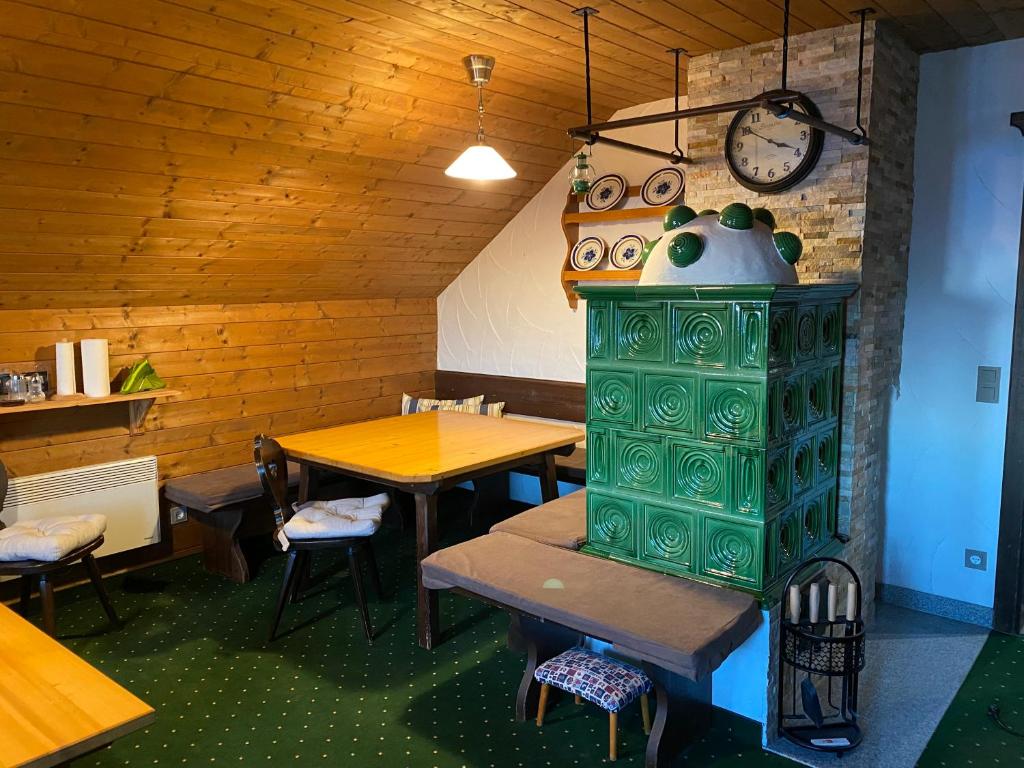 un restaurant avec deux tables et une horloge sur le mur dans l'établissement Apartman Vendy, à Hermagor