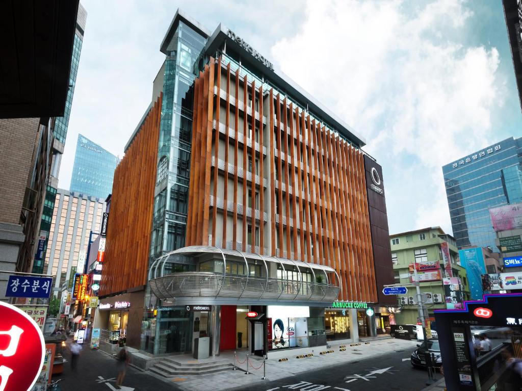 una calle de la ciudad con un edificio con un tren en Metro Hotel Myeongdong, en Seúl