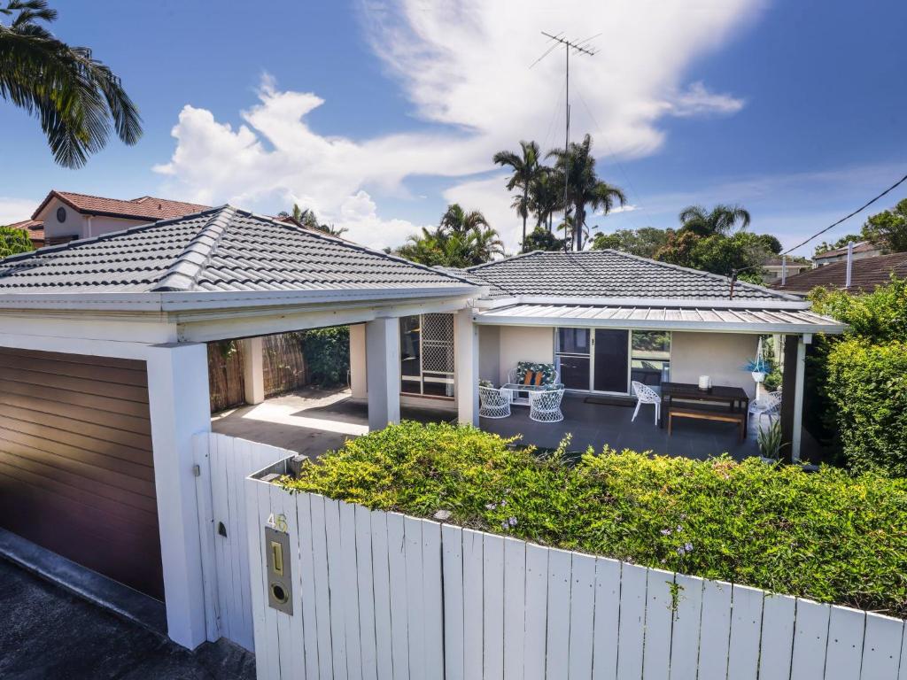 une maison avec une clôture blanche devant elle dans l'établissement Happy Dayz - Pet Friendly - Walk to Dog Beach, Restaurants & Playgrounds, à Gold Coast