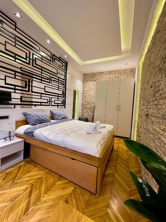 a bedroom with a large bed and a brick wall at The Bohemian Residence in Belgrade