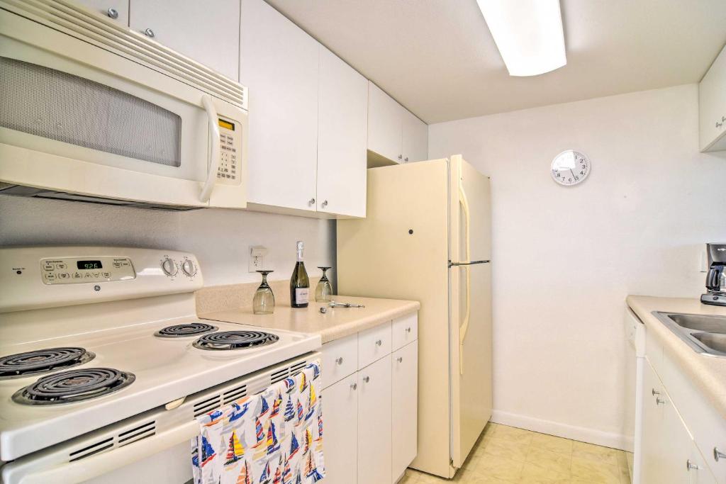 a white kitchen with a stove and a microwave at Coastal Madeira Beach Condo - Walk to Gulf! in St Pete Beach