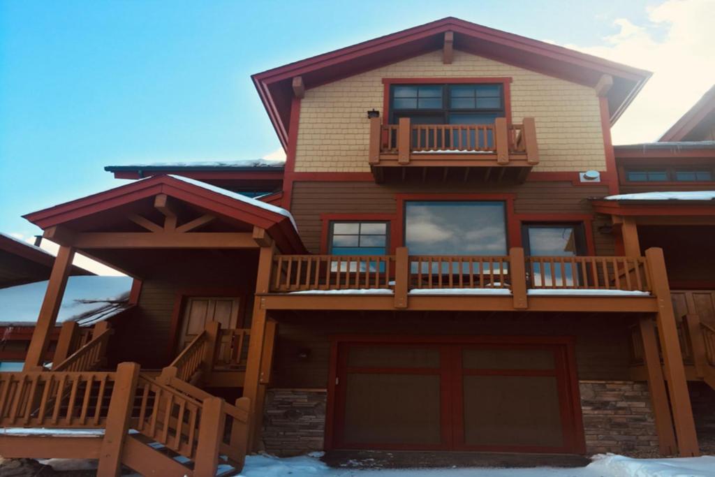 a large wooden house with a balcony and snow at Bear Crossing 845 in Winter Park