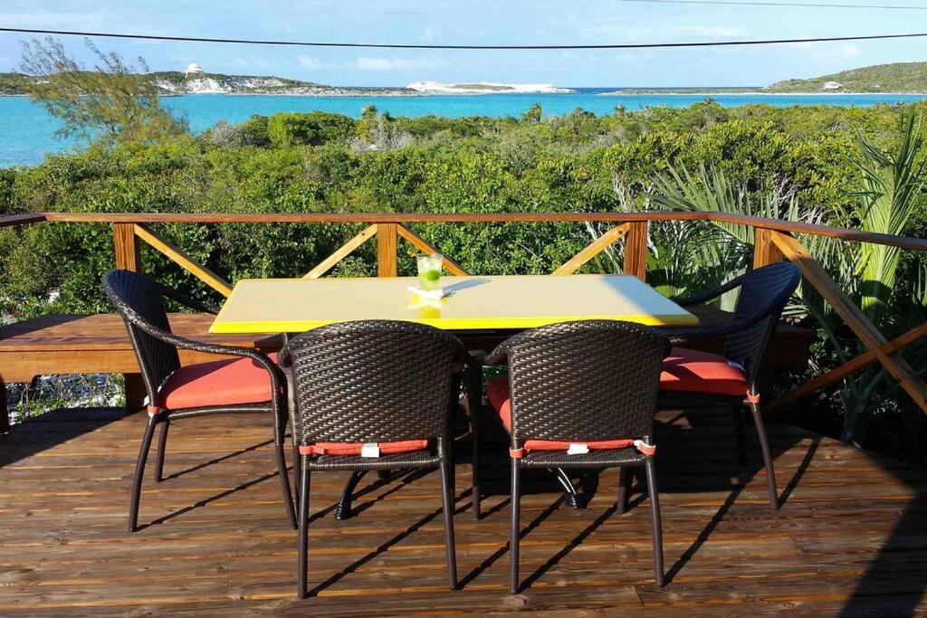een gele tafel en stoelen op een houten terras bij Ruby - Ocean view with privacy in Staniel Cay