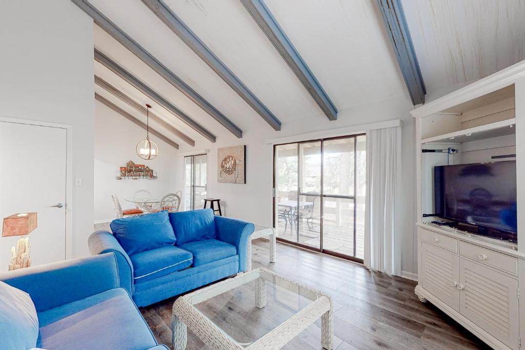 a living room with a blue couch and a tv at Seascape Golf Villas 11G in Destin