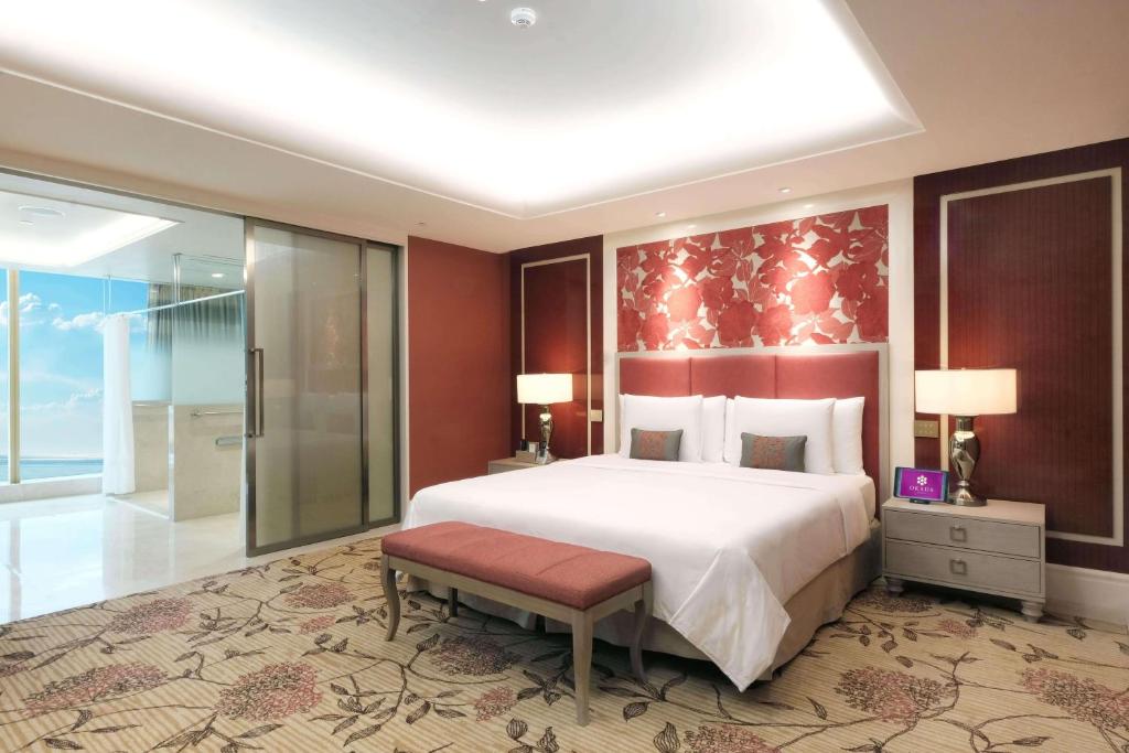 a bedroom with a large bed and a walk in shower at Okada Manila in Manila