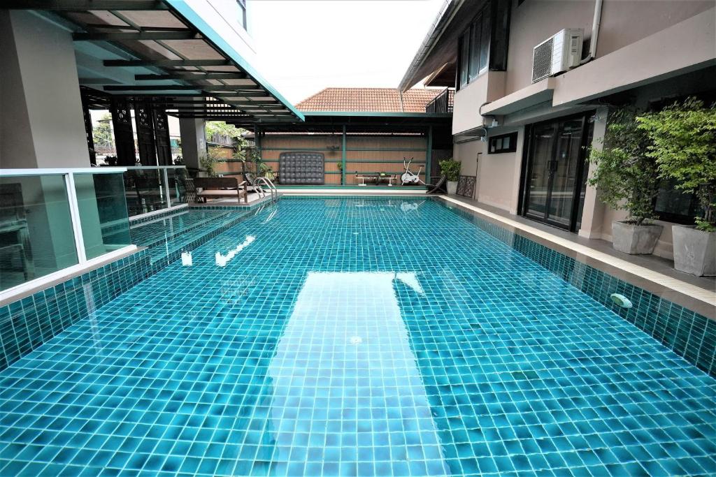 - une piscine au milieu d'un bâtiment dans l'établissement Baan Tanwa - MRT Ratchadapisek, à Bangkok