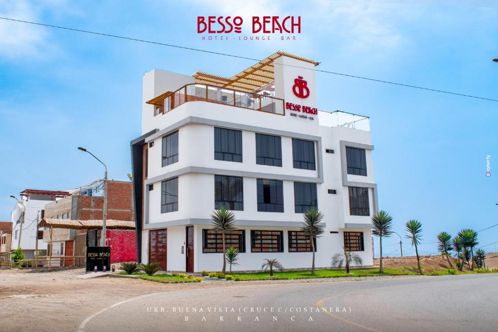 un edificio blanco al lado de una calle en Besso Beach Hotel, en Barranca