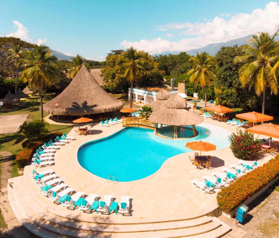 an aerial view of a resort pool with chairs and umbrellas at Hotel y Spa Santa Fe Colonial in Santa Fe de Antioquia