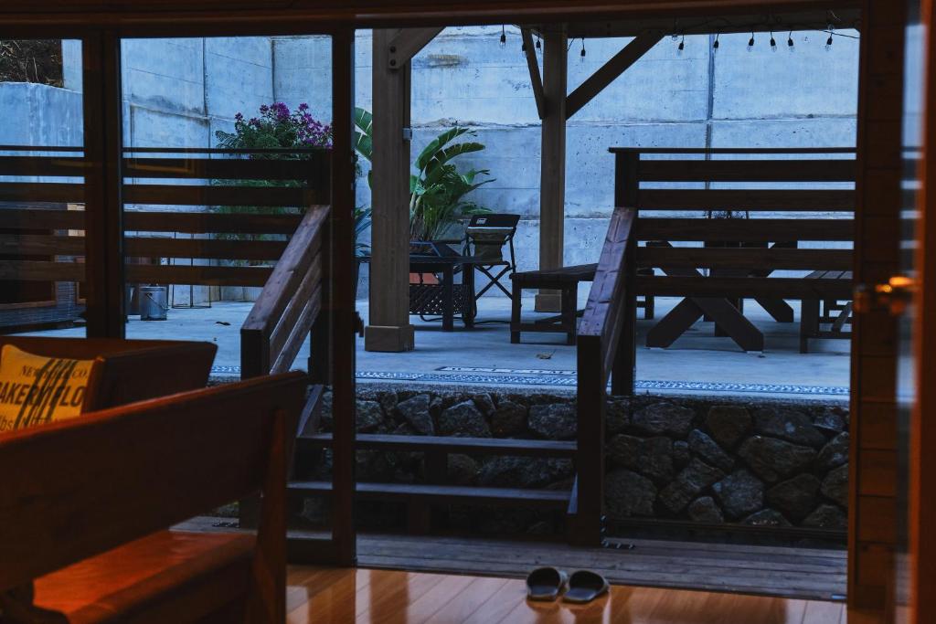 um alpendre com dois bancos, uma mesa e cadeiras em Little Hermit by SANA em Tateyama