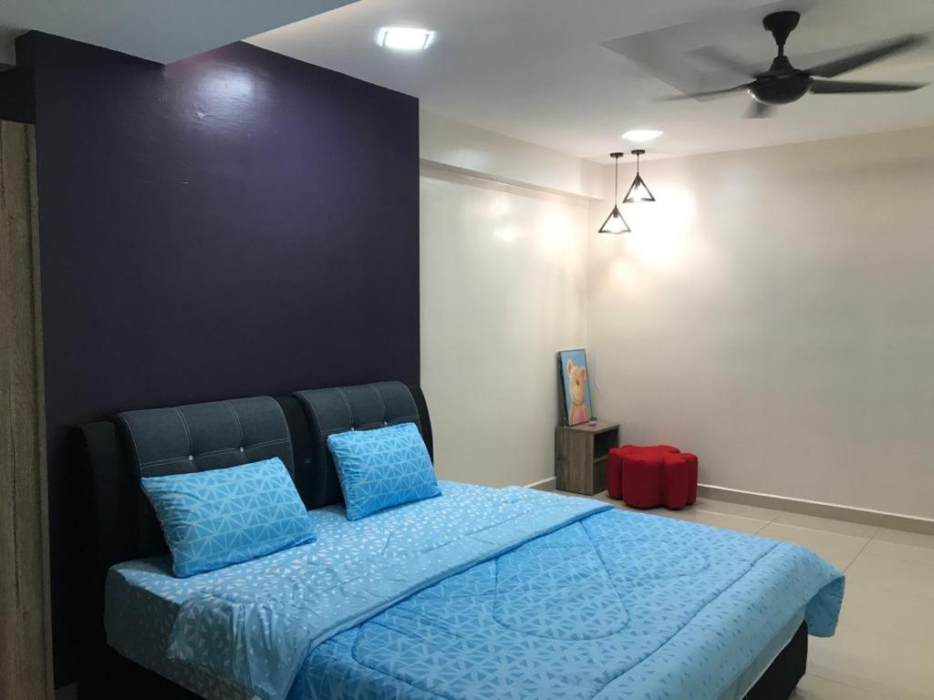Schlafzimmer mit einem blauen Bett und einem Deckenventilator in der Unterkunft WL Homestay in Sitiawan