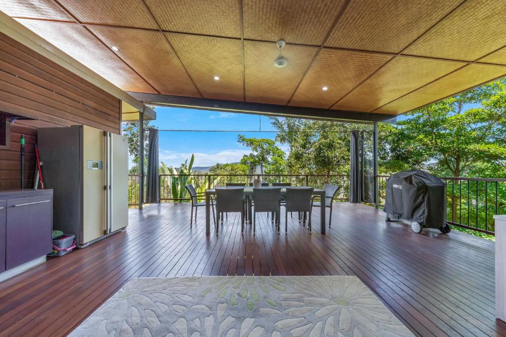 a dining room with a table and chairs on a deck at Hilltop Views - Cannonvale in Airlie Beach