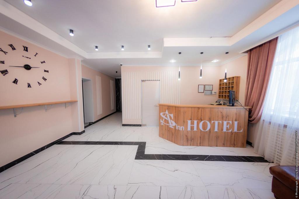 a hotel lobby with a large clock on the wall at AS Inn Hotel in Karagandy