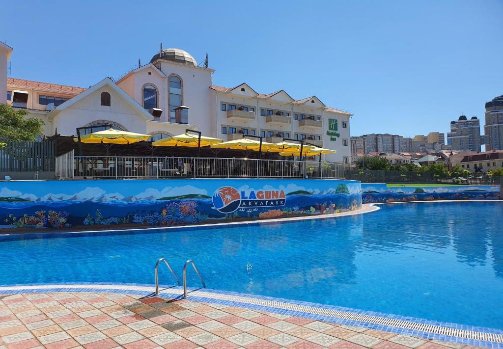 une grande piscine avec un bâtiment en arrière-plan dans l'établissement Holiday Inn - Aktau - Seaside, an IHG Hotel, à Aktau