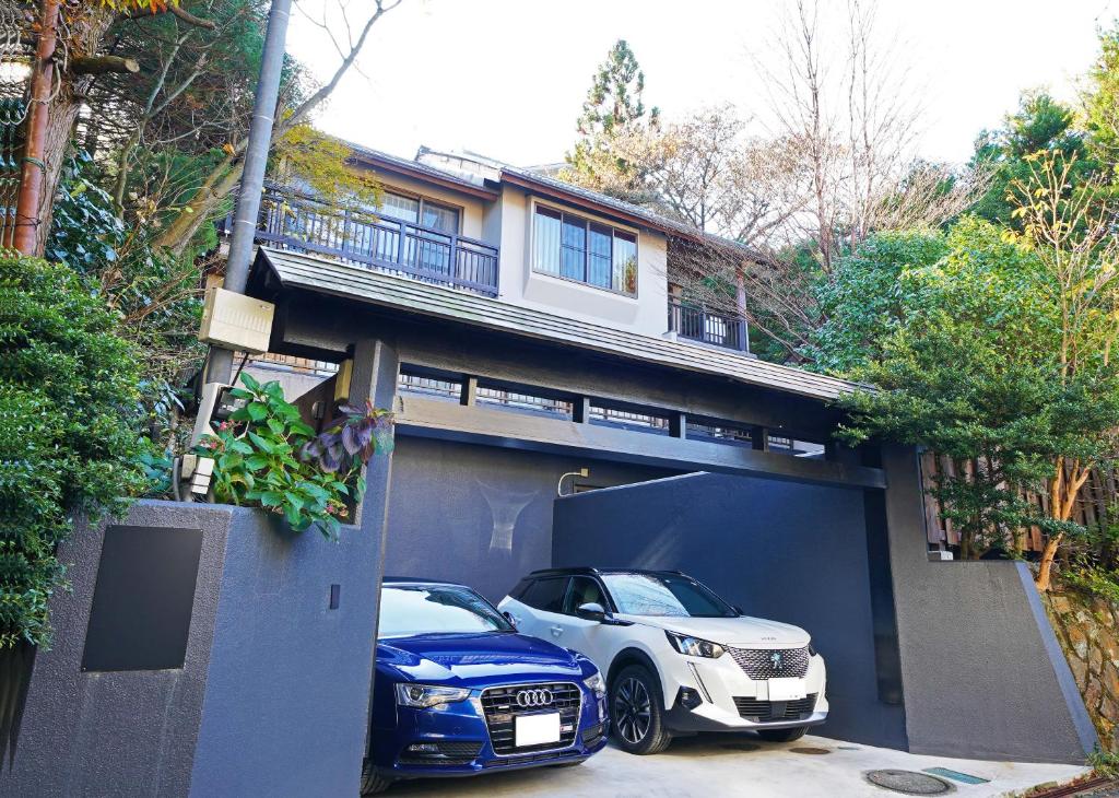 a house with two cars parked in a garage at Villa Liberte Hakone Gora in Hakone
