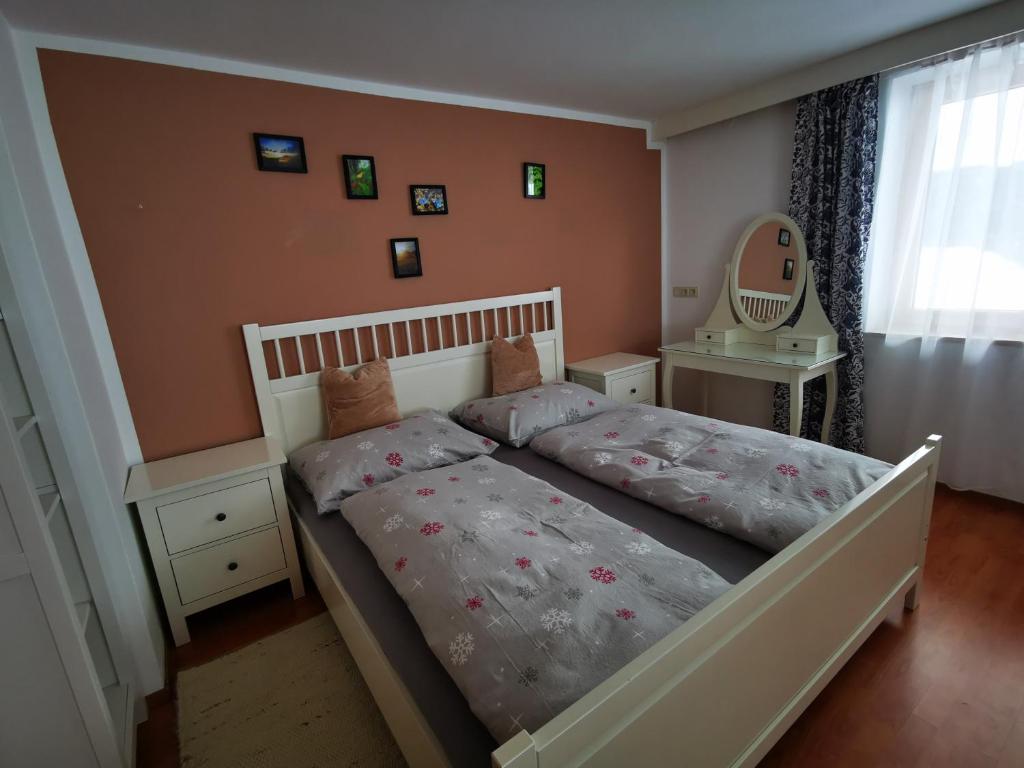 1 dormitorio con cama y espejo en la pared en Haus Gamssprung, en Steinberg am Rofan