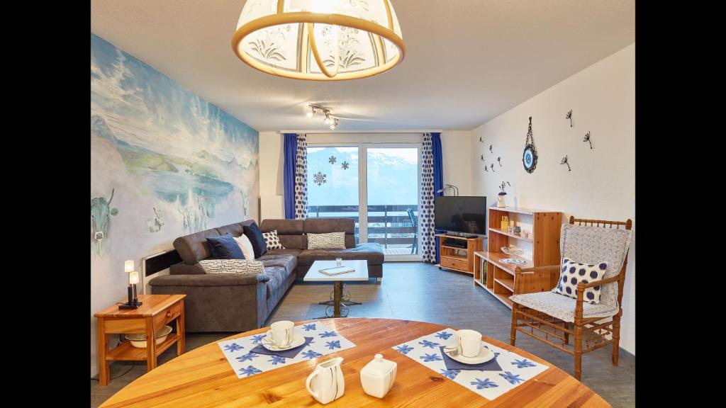 ein Wohnzimmer mit einem Sofa und einem Tisch in der Unterkunft Elfe-apartments cozy apartment with lake view for 6-7 guests in Emmetten