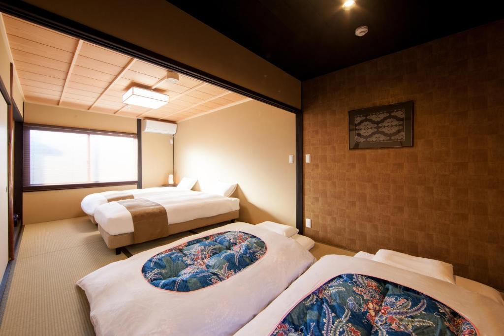 um quarto com duas camas e uma banheira em Rinn Tofukuji Kamogawa em Quioto