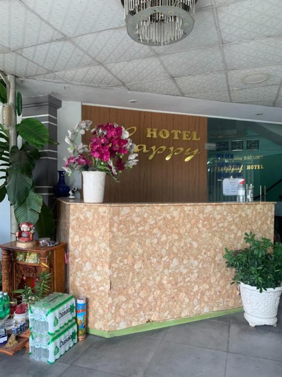 Happy Hotel Binh Tan في مدينة هوشي منه: كونتر الفندق عليه زهور