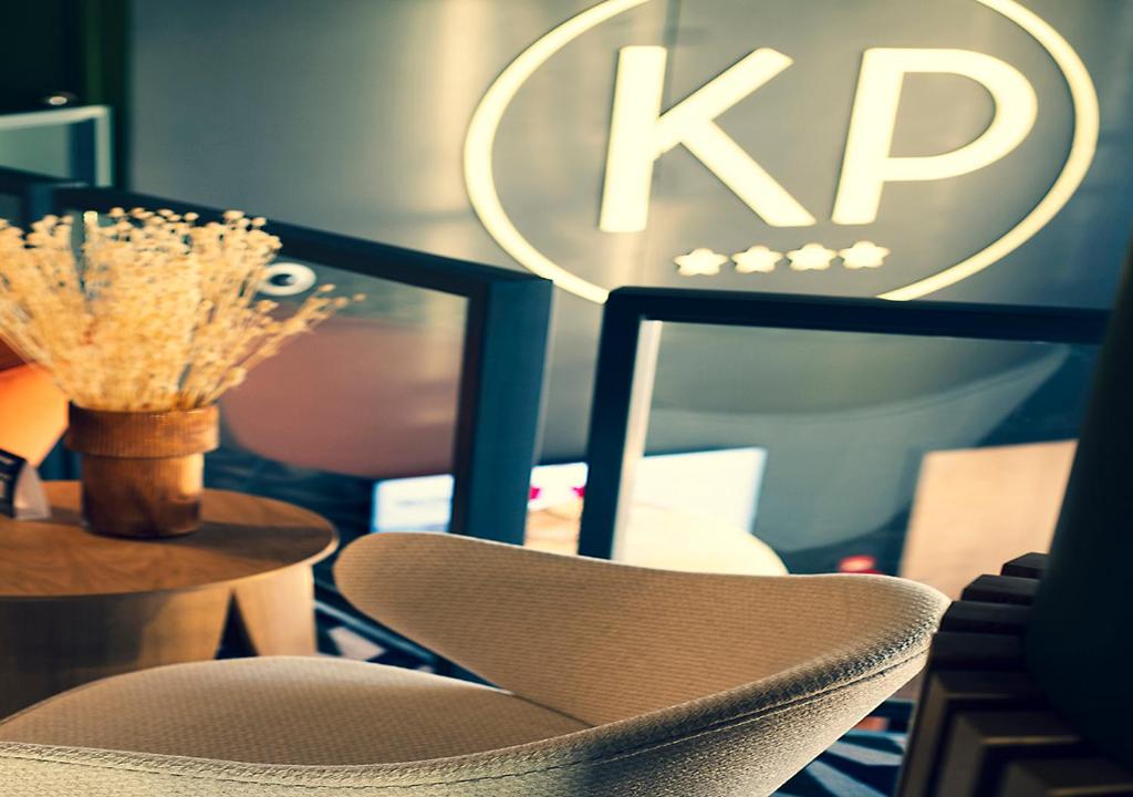 Kyriad Prestige Hotel Clermont-Ferrand في كليرمون فيران: جلسة كرسي بجانب طاولة و لافتة