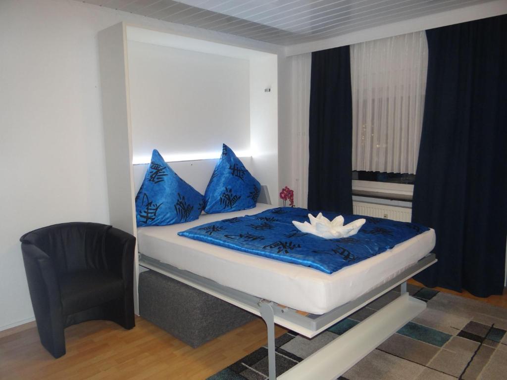 Una cama con almohadas azules y una flor blanca. en Apartment-EG-04, en Darmstadt