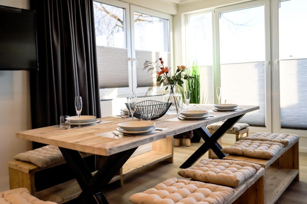 a dining room with a wooden table and some windows at Smart Resorts Haus Saphir Ferienwohnung 503 in Winterberg