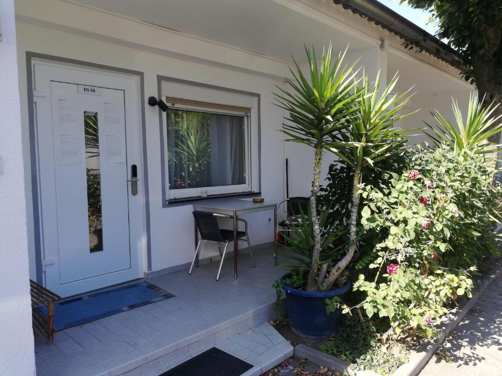 Cette maison dispose d'une terrasse couverte avec une table et une porte. dans l'établissement Apartment-EG-06, à Darmstadt