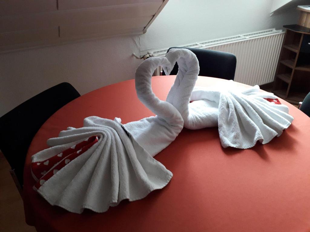 two swans made out of towels on a red table at Apart-DG in Darmstadt