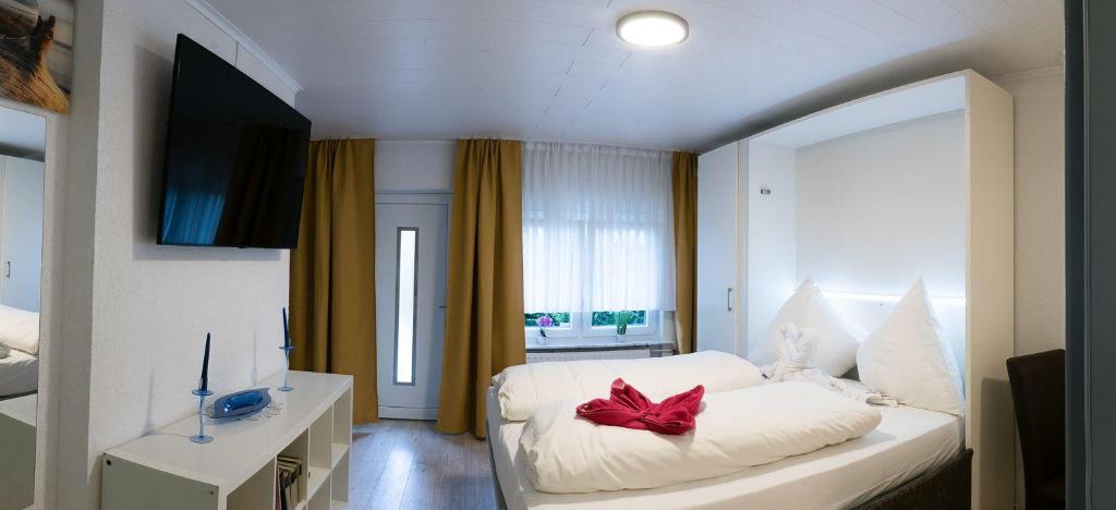 Un dormitorio con una cama blanca con un arco rojo. en Apartment-EG-09 en Darmstadt