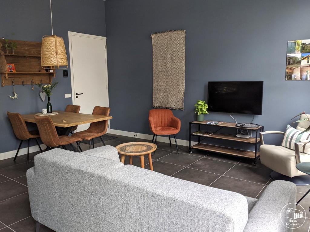 a living room with a couch and a table at Nieuw Molenwijk 4-5 persoons in Oostkapelle