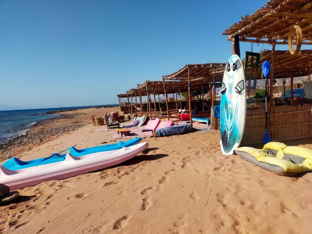 a beach with kayaks and rafts on the sand at Lala Land Camp in Nuweiba
