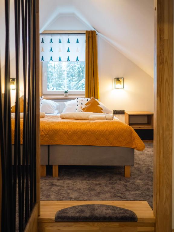 a bedroom with a large bed with a window at Domek RiverHut Małe Ciche - SkyWalk - blisko do szlaków TPN in Małe Ciche